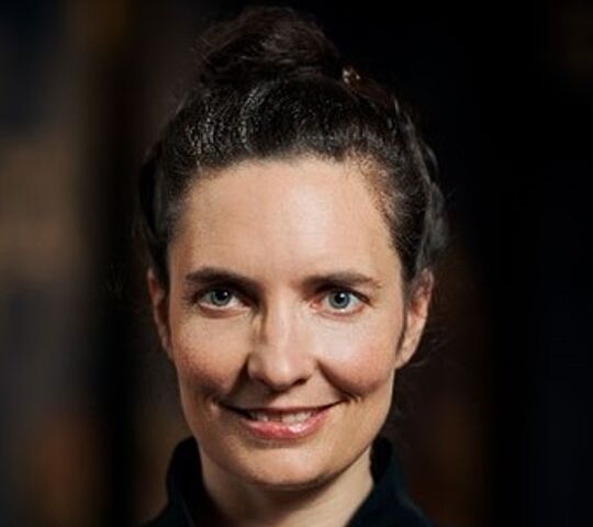 Eine Frau lächelt in die Kamera.