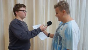 Schüler interviewt einen anderen Schüler mit einem Zoom-Gerät