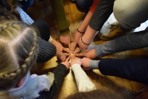 Bild eine Gruppe Jugendlicherbildet mit den Zeigefingern einen möglichst kleinen Kreis