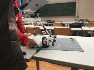 Bild: Zwei Kursteilehmenr Bauen ein Fimset aus Logo. Die Kulissa scheint einem Priratenfilm zuzugehören