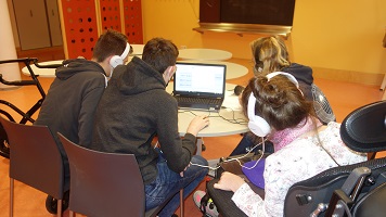 Teilnehmende sitzen hochkonzentriert um den Laptop und schneiden ihre Beiträge
