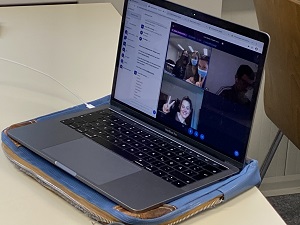 Ein Laptop, auf dem zu sehen ist, wie der digitale Raum für uns aussah. Die Bilder der anderen, der Chat und die Teilnehmendenliste