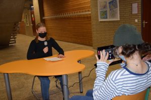 zwei Jugendliche arbeiten mit einem iPad und einem Mikrofon an einem Tisch