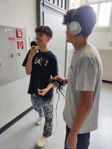Zwei Jugendliche arbeiten mit Mikrofonen und Kopfhörern
