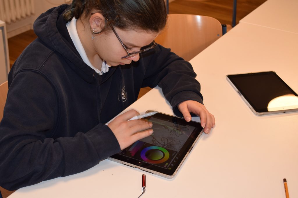 Foto zeigt Jugendliche mit Tablet und Stift beim Zeichnen.