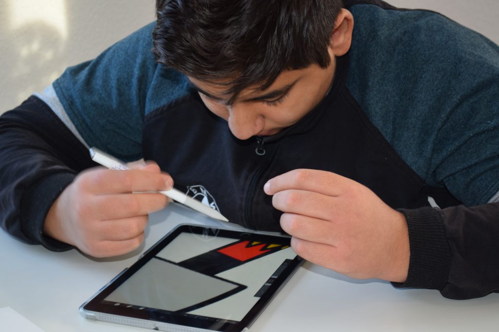 Foto zeigt einen Jungen am Tablet mit Stift.