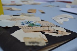 Buntes Papier und Fetzen aus alten Büchern liegen auf einem Tisch