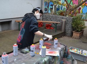 Mädchen sptüh mit Spraydosen