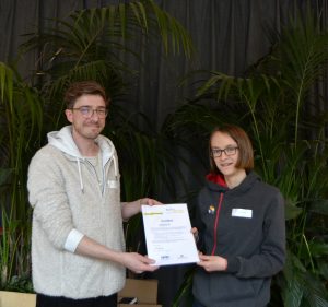 Ein Mädchen bekommt ein Zertifkat überreicht