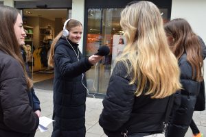Teilnehmerinnen sammeln mit Aufnahmegerät und Kopfhörern ausgesatttet Töne für Ihre Straßenumfrage
