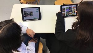 2 Jugendliche sitzen an Tablets und suchen nach Bildern.