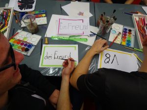 Ein kreativer werkstattisch von ober voller Stifte und papier