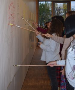 Jugendliche malen mit Stöcken auf einer Wand