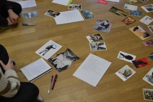 Neben einem vollgeschriebenen Notizblock liegen viele verschiedene inspirierende Postkarten