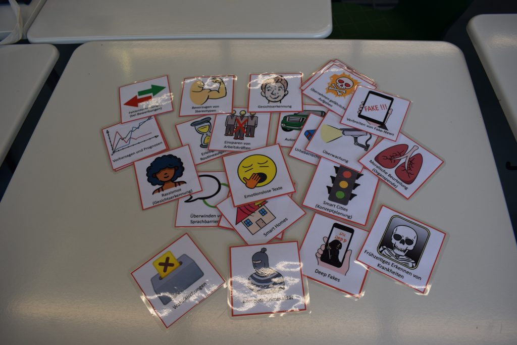 auf einem Tisch sind verschiedene Karten ausgebreitet, die die Vor- und Nachteile künstlicher Intelligenz beschreiben