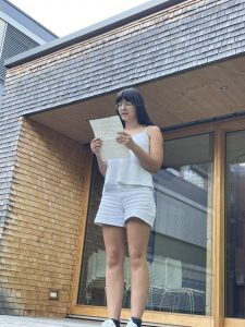 eine Teilnehmerin liest wie auf einer Bühne im Freien ihren Text vor