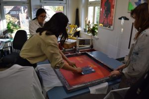 Drei Teilnehmede im Workshop Siebdruck bei der Arbeit.