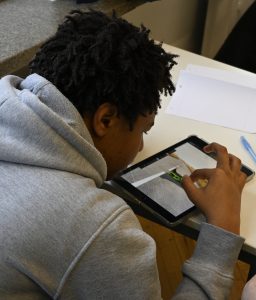 Junge bearbeitet ein Bild am Tablet