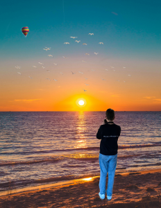 Junge mit Kamera am Strand