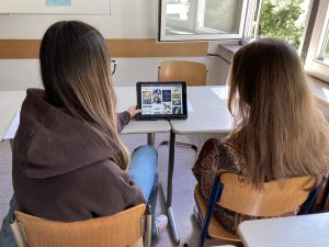 Über drei Tage hinweg fand der Workshop „Echt Fake, ich schwör!“ an einer Schule statt. Die Teilnehmenden waren eine Schulklasse mit stark handlungsorientierten Schüler*innen, die besonders für praktische und kreative Arbeitsphasen offen waren. Technisch wurde mit schuleigenen sowie mitgebrachten iPads gearbeitet, sodass die Durchführung des Workshops reibungslos möglich war.

Der erste Workshoptag war geprägt von organisatorischen Vorbereitungen und ersten inhaltlichen Annäherungen an das Thema Fake News. Nach dem Einrichten der Technik wurden theoretische Grundlagen vermittelt, die jedoch immer wieder durch aktivierende und spielerische Elemente aufgelockert wurden. Besonders das Herstellen eigener Fake-Inhalte stieß auf Interesse. Aufgrund nachlassender Konzentration wurden Theorieeinheiten verkürzt und der Tag früher beendet, wobei spielerische Übungen mit thematischem Bezug den Abschluss bildeten.

Am zweiten Tag rückten die kreative Arbeit und die Entwicklung eigener Fake-Geschichten in den Vordergrund. Nach einem gemeinsamen Einstieg begannen die Schüler*innen, Ideen zu entwickeln und in Gruppen umzusetzen. Die Aussicht auf das Filmen mit iPads wirkte dabei motivierend. In der freien Arbeitsphase arbeiteten die Gruppen zunehmend selbstständig an ihren Konzepten, erstellten erste Fake-Beweise und begannen teilweise mit der Ausarbeitung von Drehbüchern.

Der dritte Tag stand ganz im Zeichen der praktischen Umsetzung. Die Schüler*innen arbeiteten eigenständig an ihren Filmprojekten weiter und unterstützten sich gegenseitig. Ein besonderes Highlight war der Einsatz des Greenscreens. Zum Abschluss des Workshops wurden die entstandenen Filme im Plenum präsentiert. In einer kurzen Reflexionsrunde wiederholten die Teilnehmenden die zentralen Inhalte des Projekts und setzten sich damit auseinander, wie sie künftig mit Nachrichten und Informationen aus dem Internet umgehen möchten.