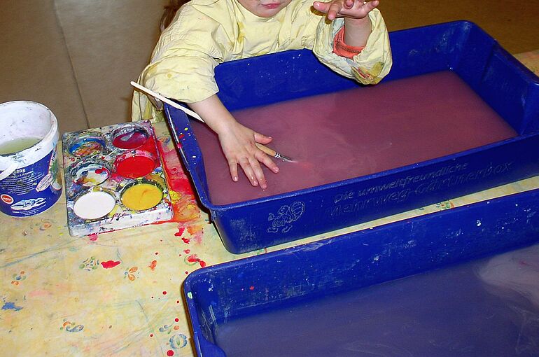 Ein Kind benutzt Wasserfarben