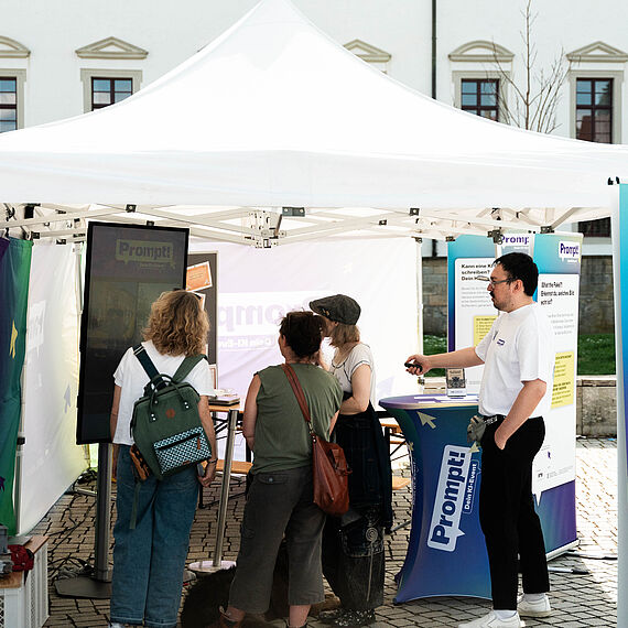 Zeltstand mit mehreren Personen im Gespräch 