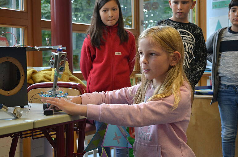Mädchen präsentiert ihren selbstgebauten Roboter aus Elektroschrott