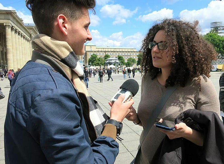 Jugendlicher interviewt junge Frau auf der Königsstraße in Stuttgart