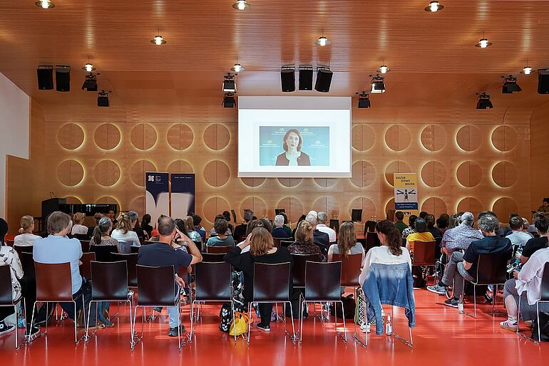 Publikum sitzend von hinten fotografiert 