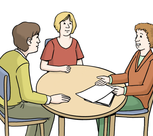 3 erwachsene Menschen sitzen um einen Tisch, der eine berätdie anderen beiden