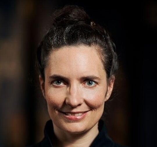 Eine Frau lächelt in die Kamera.